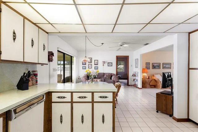 a kitchen with a sink dishwasher and white cabinets with wooden floor