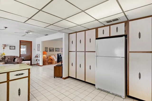 a kitchen with stainless steel appliances a refrigerator a stove and white cabinets