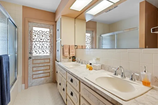 a bathroom with a granite countertop sink and a large mirror