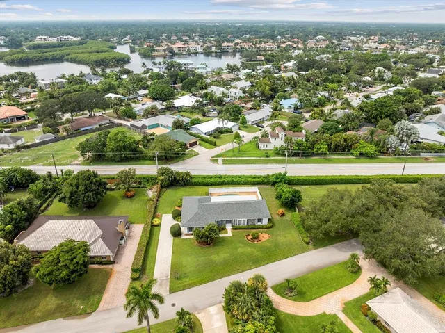 an aerial view of a house with swimming pool garden and tall buildings