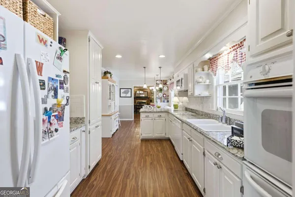 a kitchen with granite countertop cabinets stainless steel appliances and wooden floor