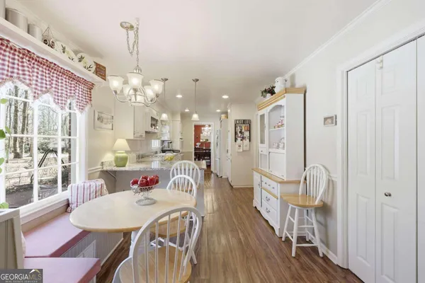 a dining room with furniture wooden floor a rug and a chandelier