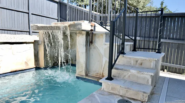 a view of a backyard with tub and wooden fence