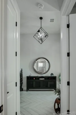 a view of a hallway with wooden floor and a bathroom