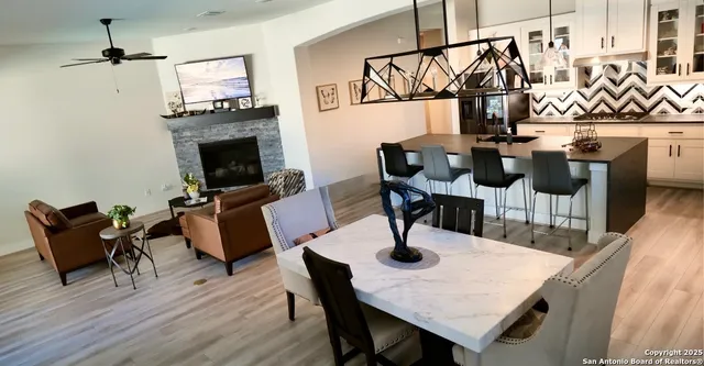 a living room with furniture a fireplace and a large window