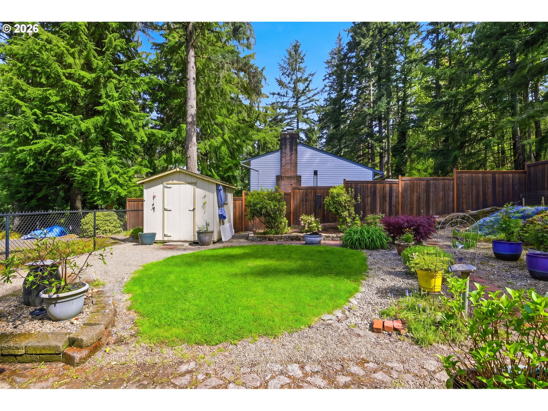 88119 Tiki Lane Springfield, OR 97478 - Photo 31 of 35 a view of a back yard with flower plants and wooden fence