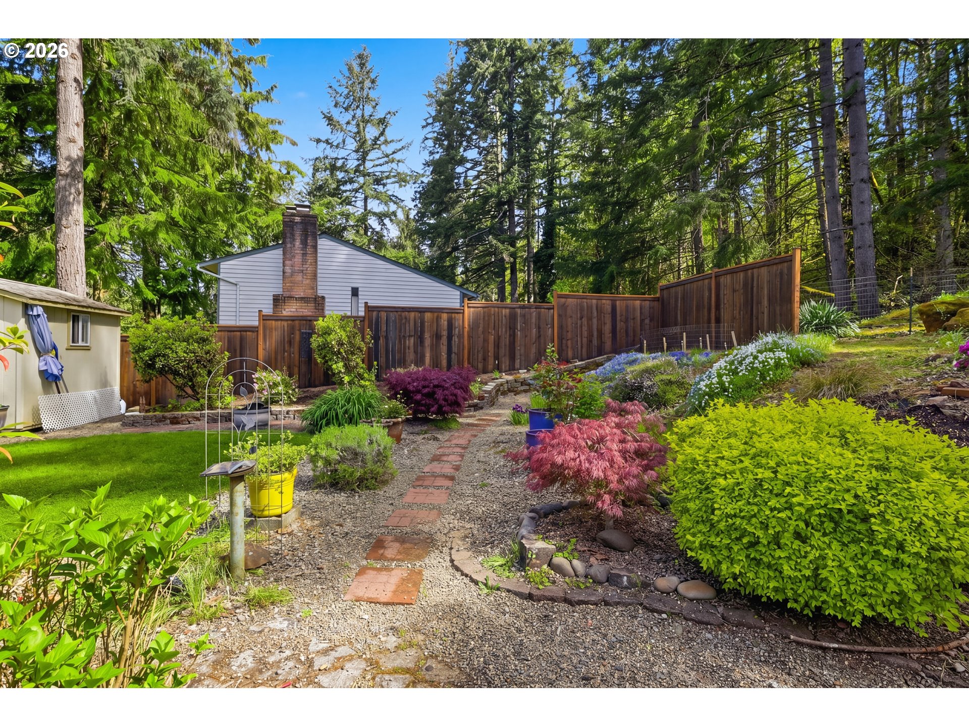 88119 Tiki Lane Springfield, OR 97478 - Photo 32 of 35 a view of a backyard with plants and a bench