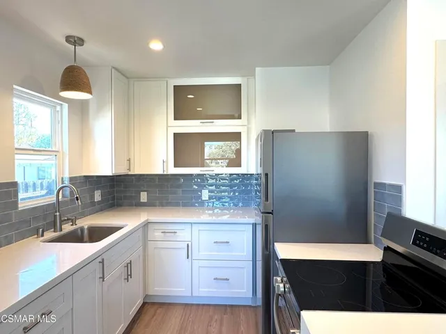 a kitchen with a sink dishwasher a refrigerator and cabinets