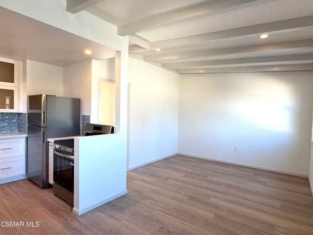 a view of kitchen with furniture and refrigerator