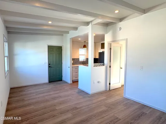 a view of a kitchen with wooden floor and a refrigerator