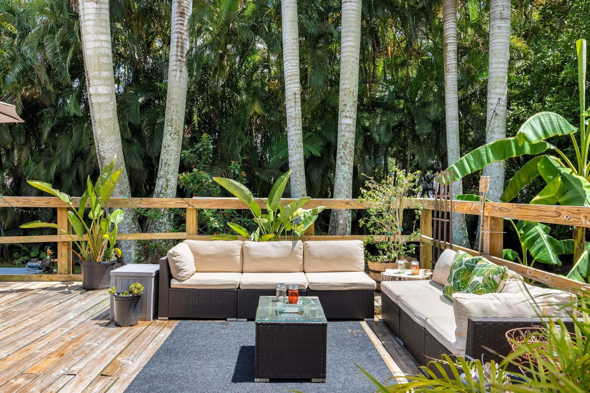 5021 Southwest 201st Terrace Southwest Ranches, FL 33332 - Photo 39 of 50 a view of a patio with couches table and chairs with plants and trees
