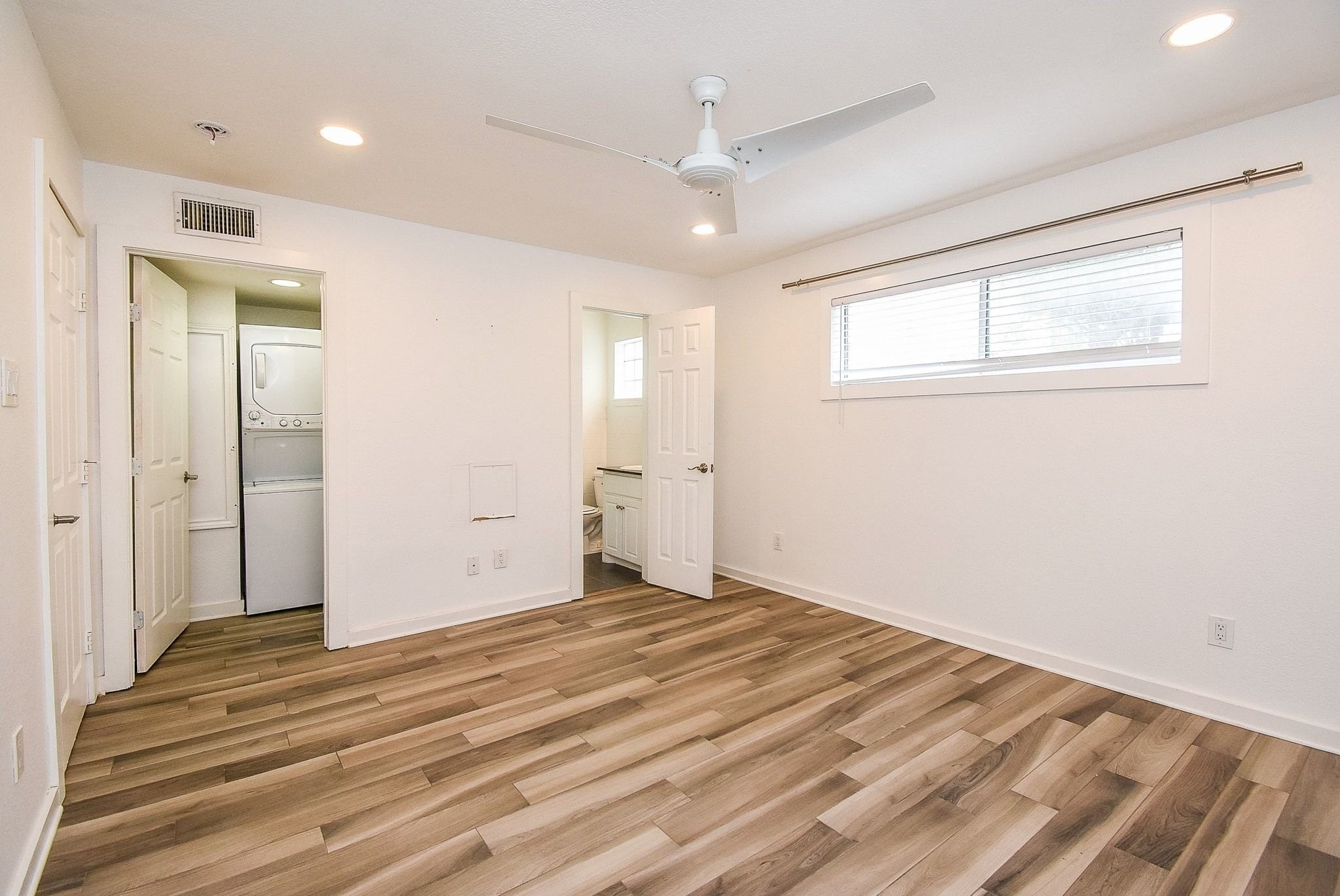 1404 Welch Street, Unit 2 Houston, TX 77006 - Photo 14 of 20 Spacious bedroom with recessed lighting, ceiling fan, wood-look flooring, and direct access to the ensuite bath and laundry area.