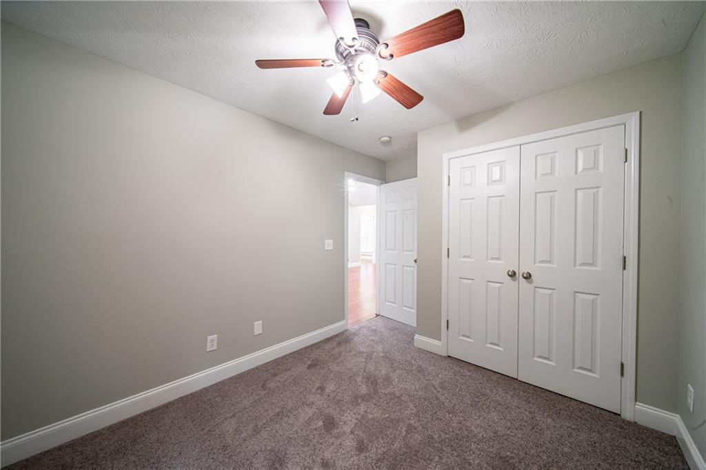 1927 Lee Road Salem, AL 36874 - Photo 38 of 45 Unfurnished bedroom featuring dark carpet, ceiling fan, a textured ceiling, and a closet