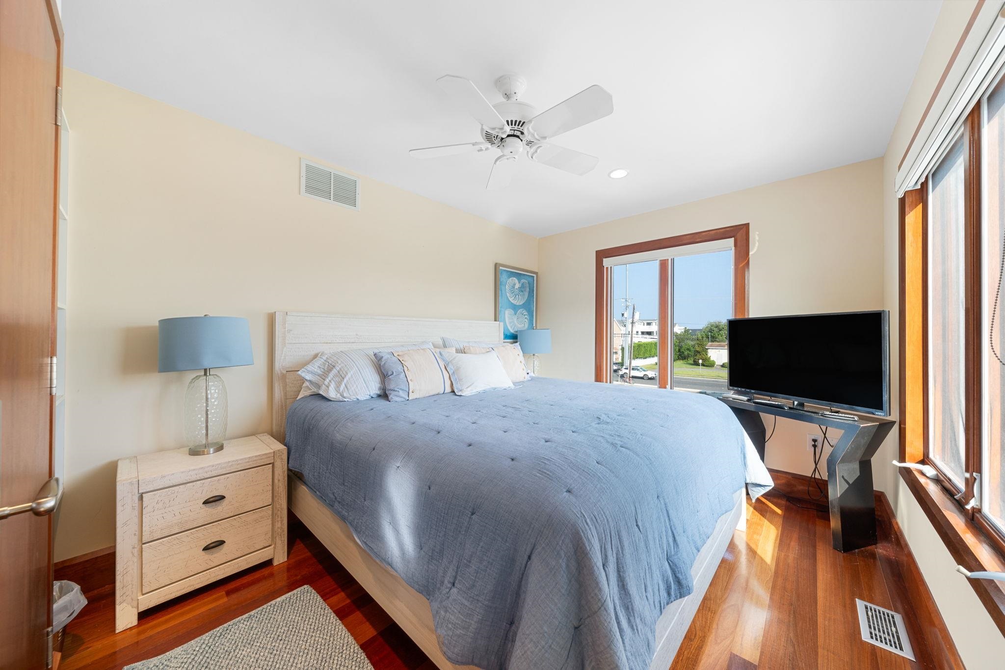 5878 Ocean Drive Avalon, NJ 08202 - Photo 46 of 50 a bedroom with a bed and a flat tv screen on dresser