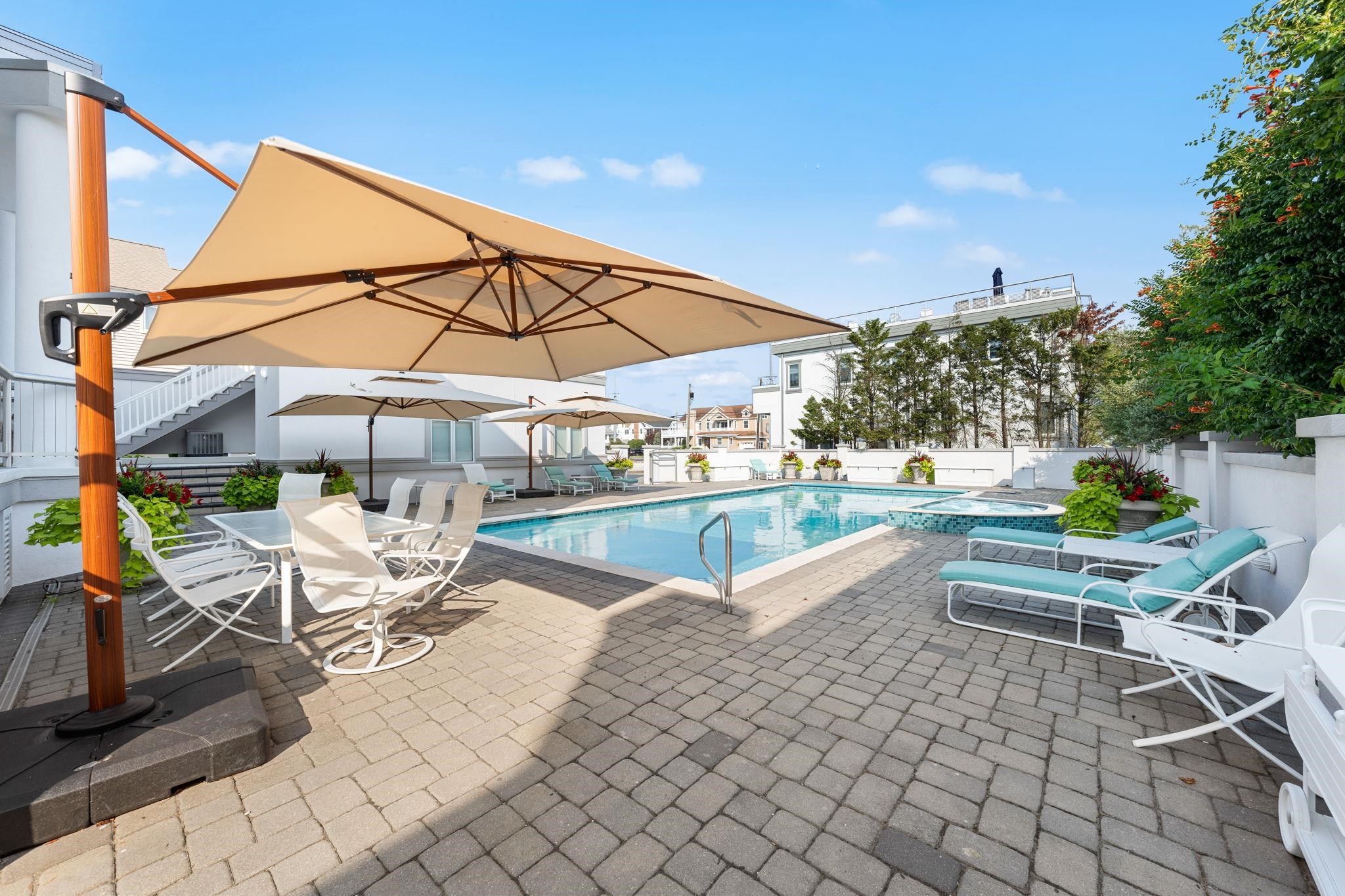 5878 Ocean Drive Avalon, NJ 08202 - Photo 5 of 50 a view of a patio with a table and chairs under an umbrella