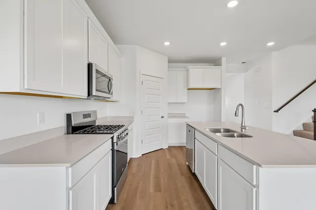 a kitchen that has a sink a stove and cabinets
