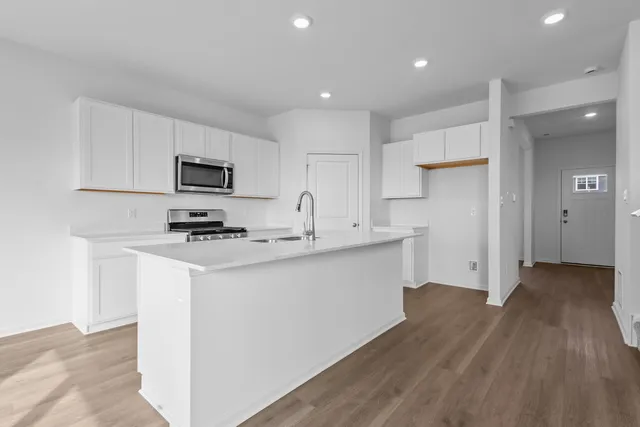 a kitchen with a sink a microwave a refrigerator and cabinets