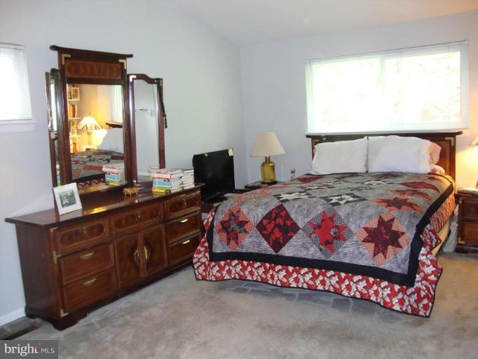822 Hopewood Road Pikesville, MD 21208 - Photo 5 of 9 a bedroom with a bed and a mirror
