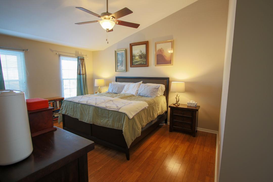 2136 Sunrise Circle Aurora, IL 60503 - Photo 12 of 21 a bedroom with a bed and a table with wooden floor