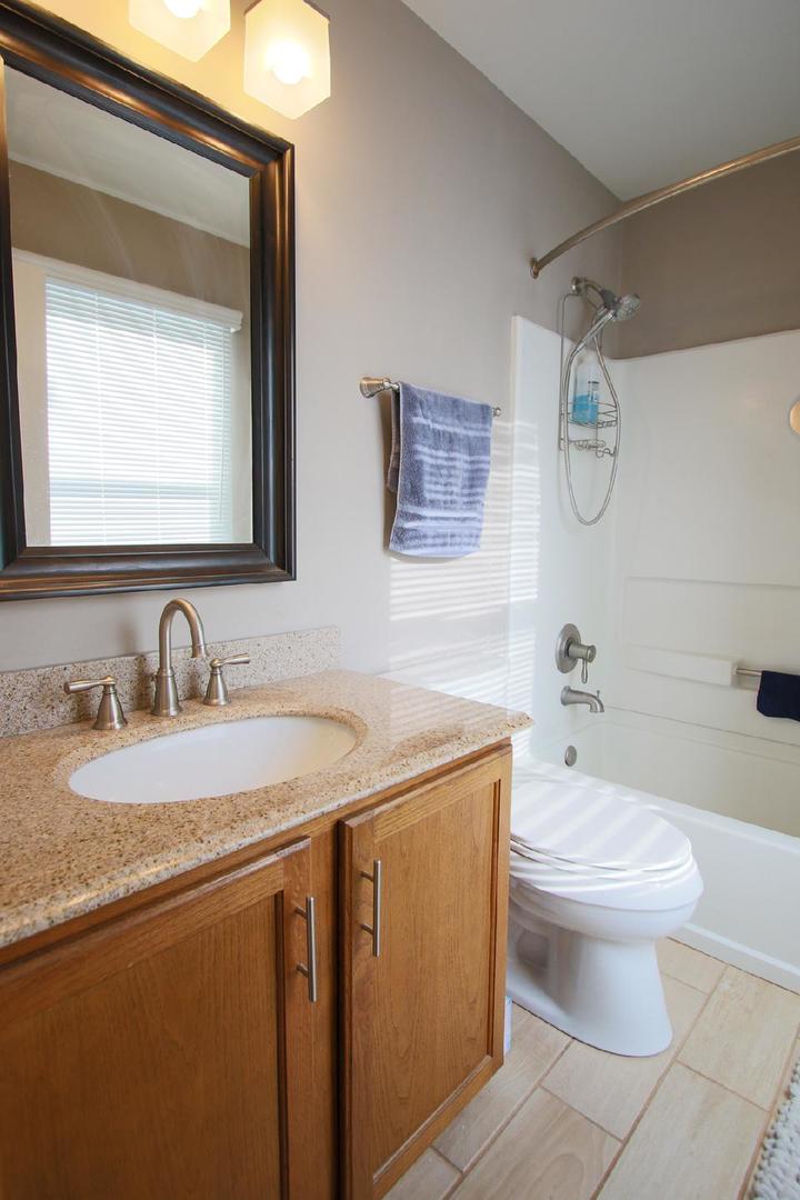2136 Sunrise Circle Aurora, IL 60503 - Photo 19 of 21 a bathroom with a granite countertop sink a toilet and a mirror