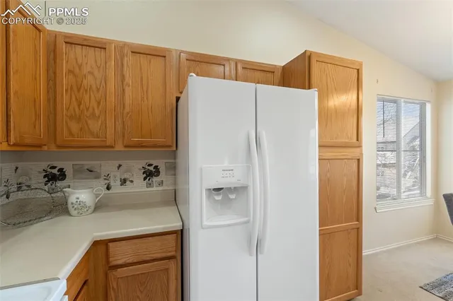 a bathroom with a refrigerator a sink and cabinets
