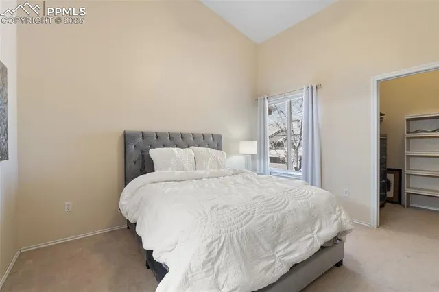 a large bed sitting in a bedroom and lamp