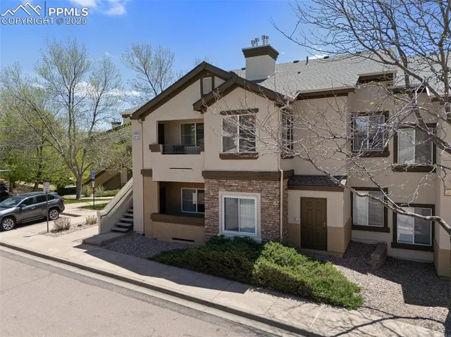 a view of a white house with large windows and a yard