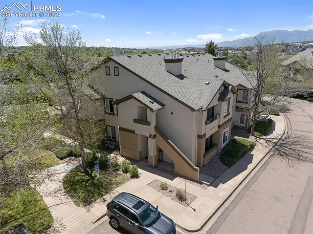 an aerial view of a house with a mountain