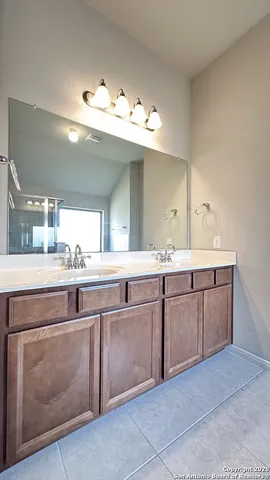 a bathroom with a sink vanity and mirror