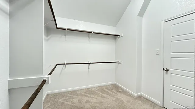 a view of walk in closet with empty racks