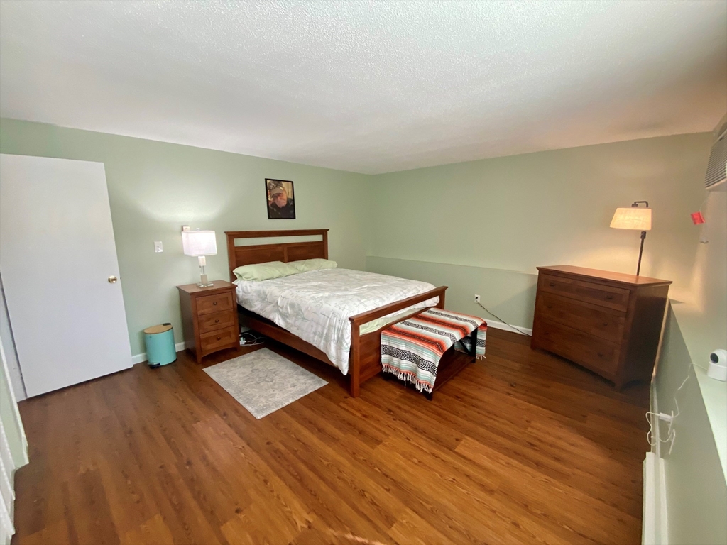 200 Manning Street, Unit 2B Hudson, MA 01749 - Photo 6 of 9 a bedroom with a bed and wooden floor