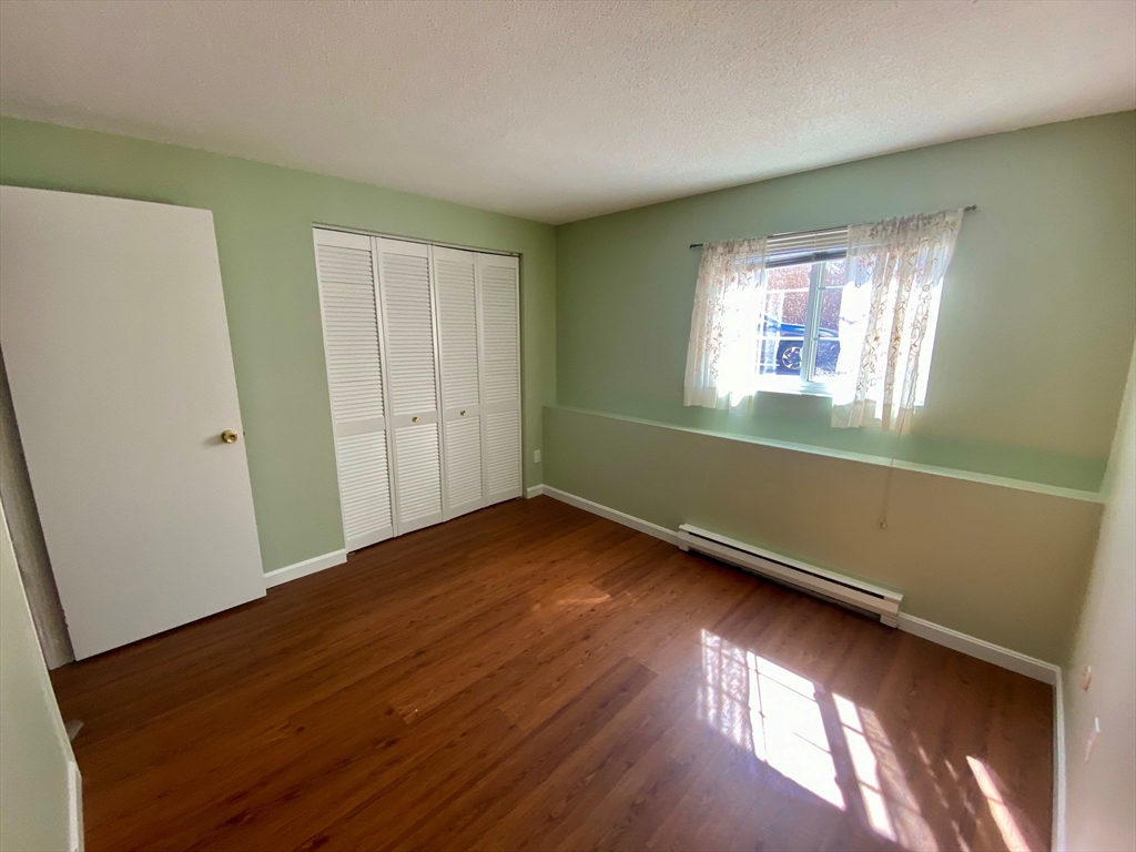 200 Manning Street, Unit 2B Hudson, MA 01749 - Photo 8 of 9 a view of an empty room with wooden floor and a window