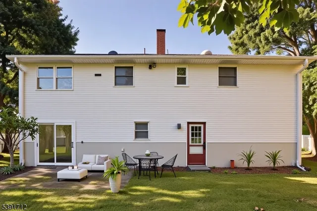 a view of a patio with table and chairs potted plants and large tree