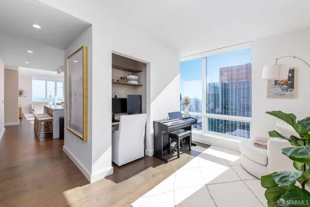 a living room with furniture a dining table and a refrigerator