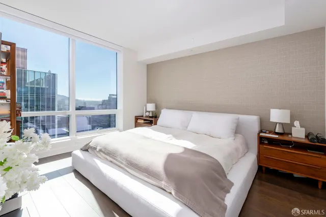 a bedroom with a bed wooden floor and window