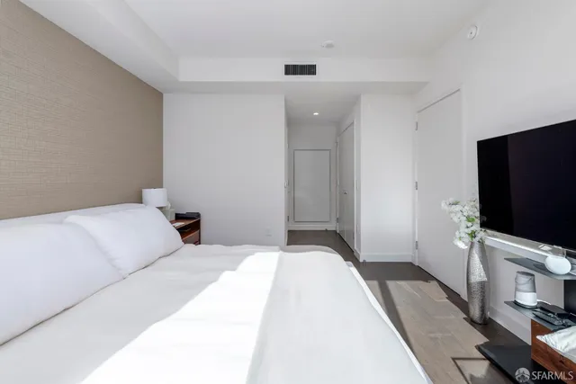 a bedroom with a bed and a flat screen tv