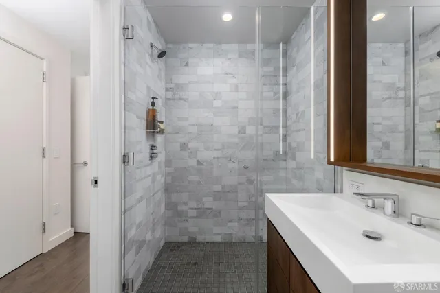 a bathroom with a sink shower and a mirror