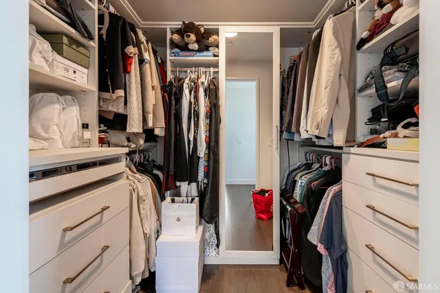 a view of walk in closet with clothes and shoes