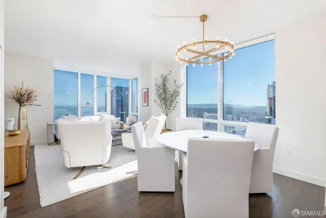 a dining room with furniture a chandelier and wooden floor
