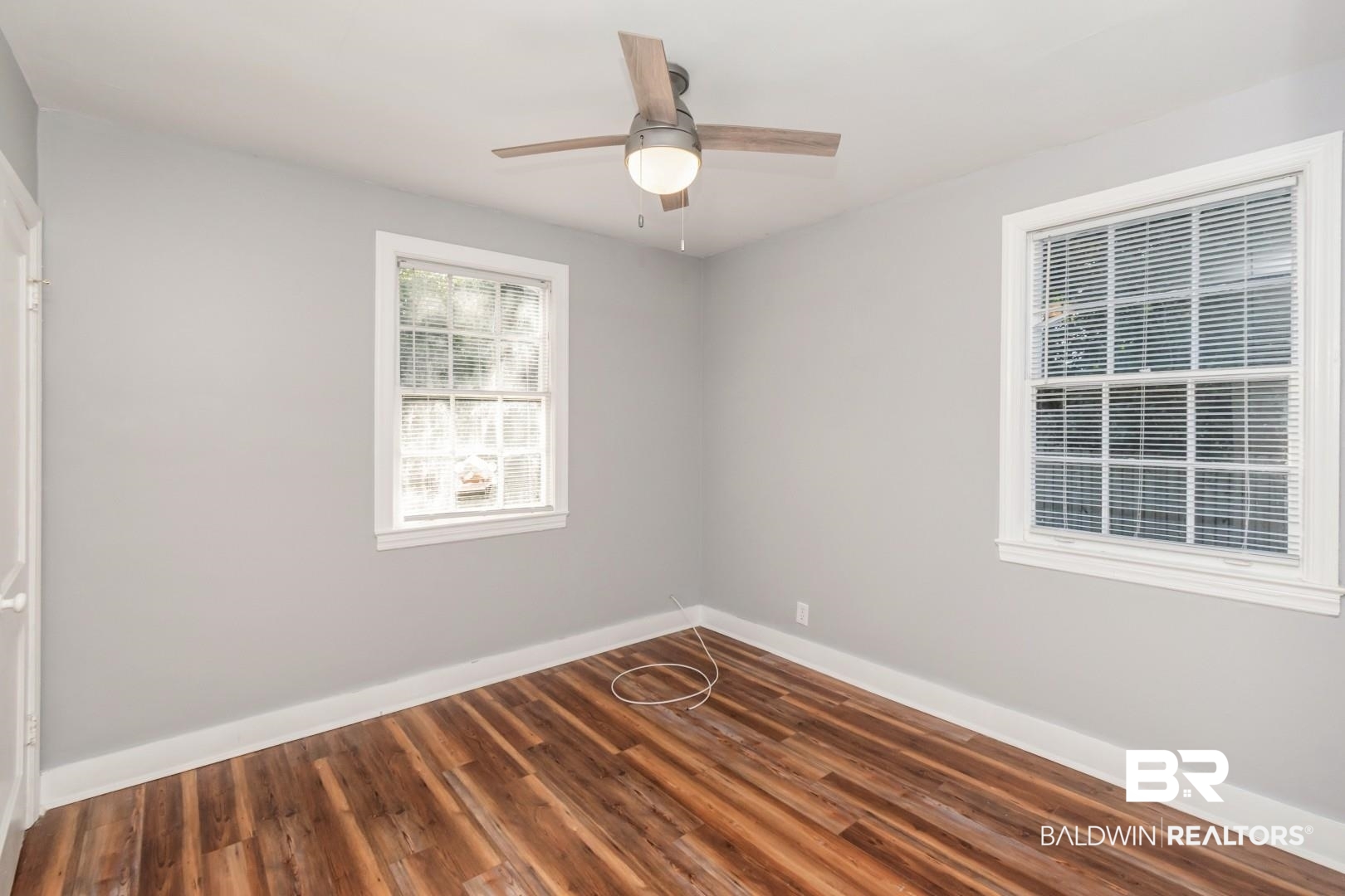 263 Border Drive East Mobile, AL 36608 - Photo 15 of 27 Room featuring wood-finish flooring, two windows with white trim, and a ceiling fan with integrated lighting