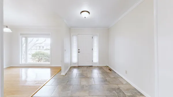 a view of a living room with stainless steel appliances wooden floor and a large window