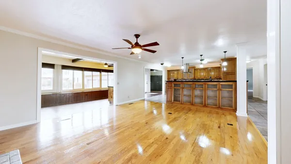 a kitchen with stainless steel appliances granite countertop wooden cabinets a sink a stove a dining table and chairs