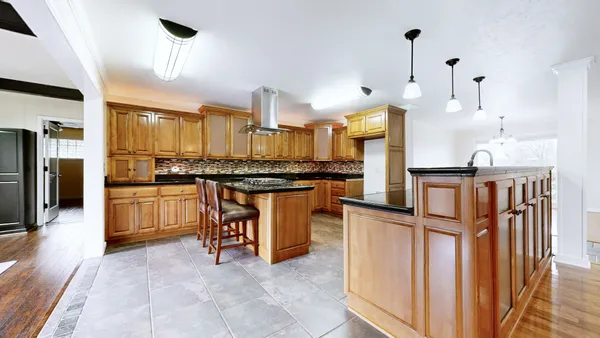 a view of a livingroom with a fireplace a ceiling fan and wooden floor