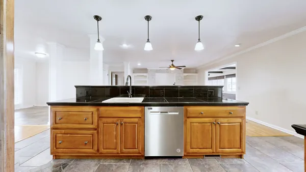 a kitchen with stainless steel appliances a refrigerator and a wooden floor