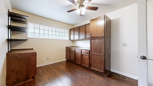 a view of empty room with wooden floor and cabinet