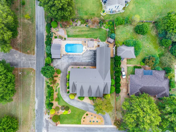 an aerial view of a house with outdoor space and swimming pool