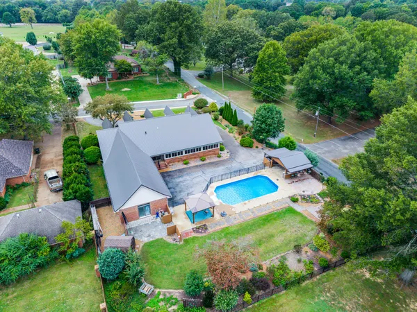 an aerial view of a house with a garden swimming pool and outdoor seating