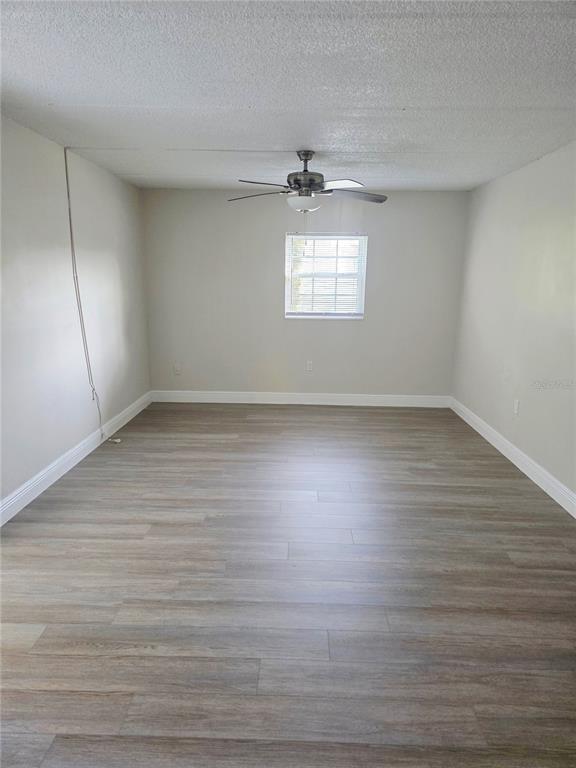 525 South Conway Road, Unit 53 Orlando, FL 32807 - Photo 9 of 12 an empty room with wooden floor cabinets and windows