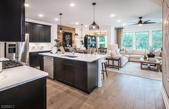 a open kitchen with stainless steel appliances kitchen island granite countertop a stove and a sink