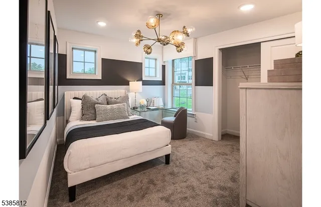 a spacious bedroom with a bed and a chandelier